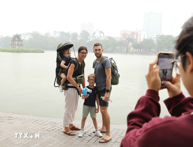 Du khách quốc tế lưu giữ những khoảnh khắc đáng nhớ cùng Tháp Rùa cổ kính. (Ảnh: Thành Phương/TTXVN) ttxvn-0306-du-lich-ha-noi-1.jpg